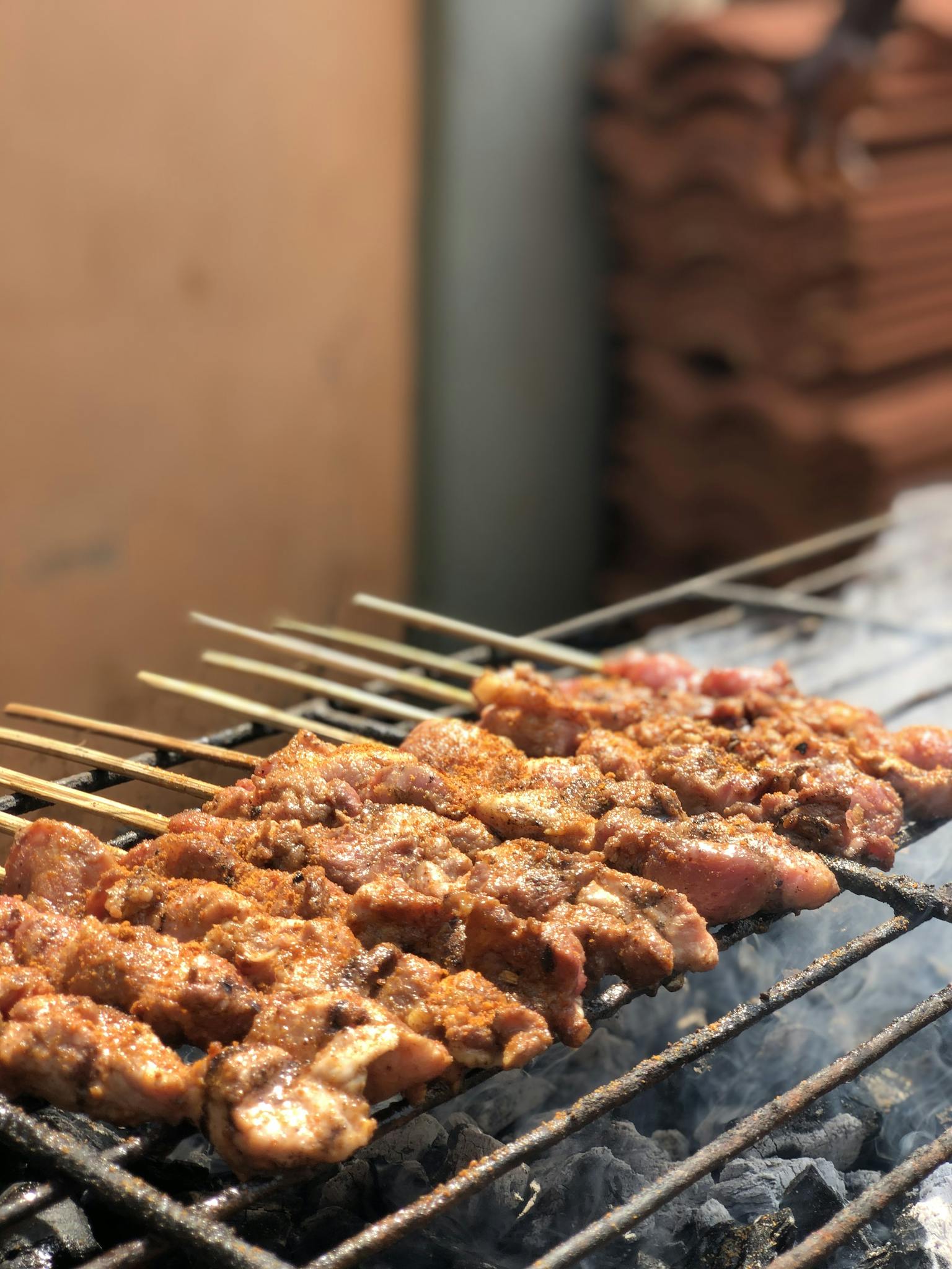 Juicy skewered meat grilling over charcoal, perfect for outdoor barbecue enthusiasts.